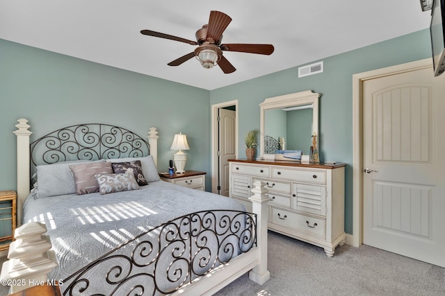 bedroom with light carpet, visible vents, and a ceiling fan