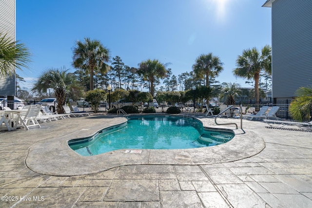 community pool featuring a patio and fence