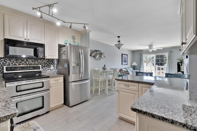 kitchen with stainless steel appliances, crown molding, backsplash, and light stone countertops