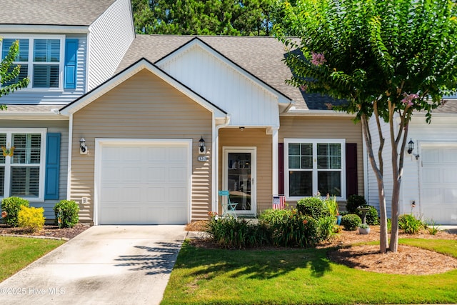 view of front of property with concrete driveway, a shingled roof, board and batten siding, and an attached garage