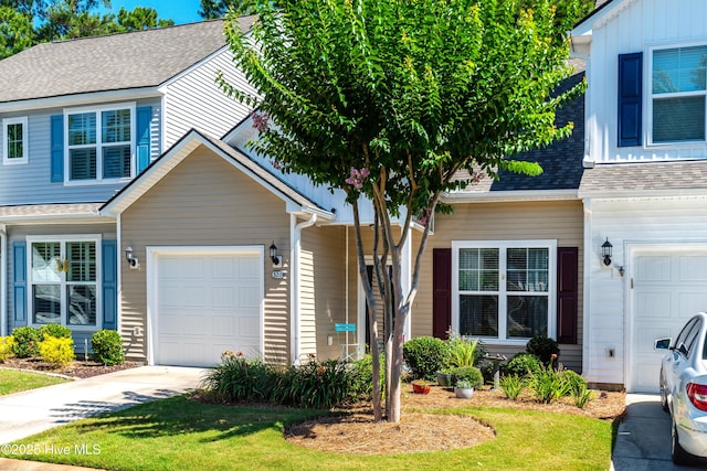 view of front of house with a garage, concrete driveway, and a shingled roof