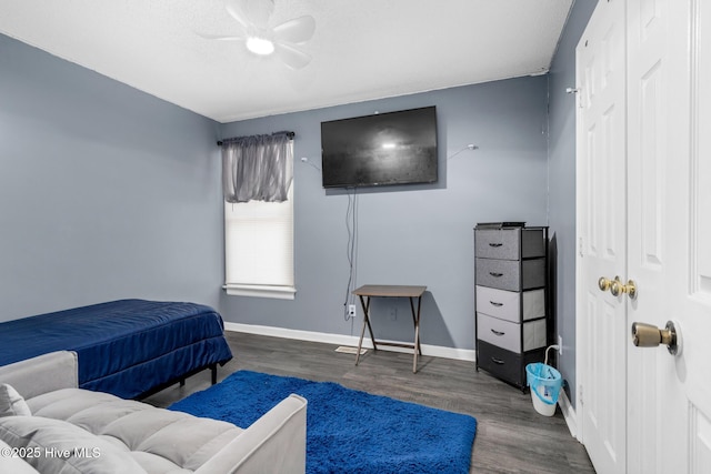 bedroom featuring dark wood-type flooring, a closet, a ceiling fan, and baseboards