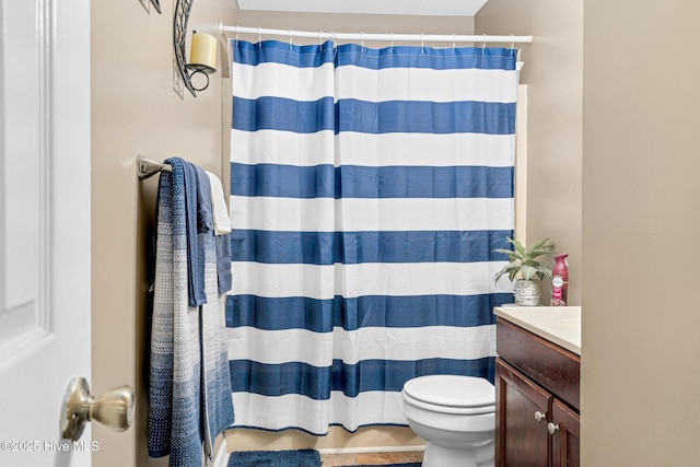 bathroom with a shower with shower curtain, toilet, and vanity