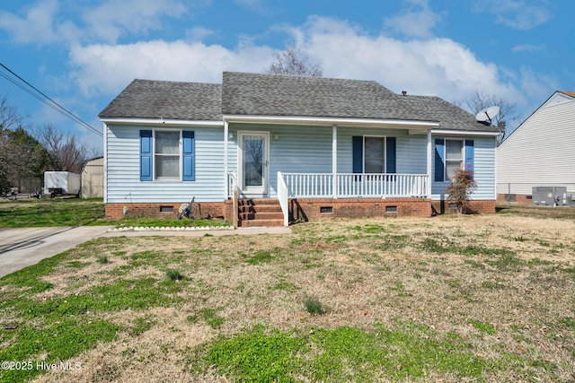 ranch-style home with a porch, a front yard, crawl space, and roof with shingles