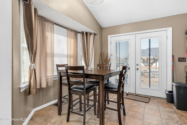 dining room featuring baseboards, vaulted ceiling, and french doors