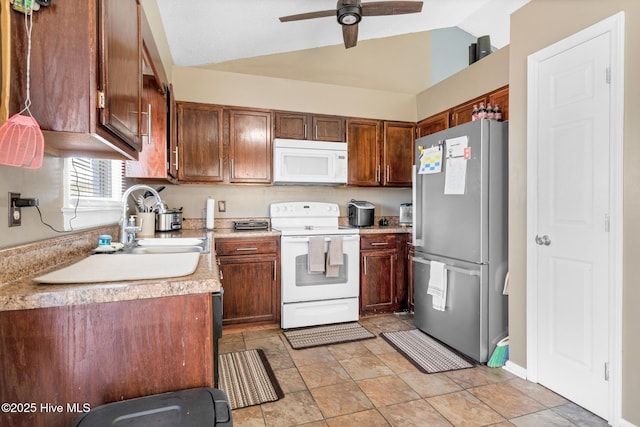 kitchen featuring lofted ceiling, white appliances, a sink, a ceiling fan, and light countertops