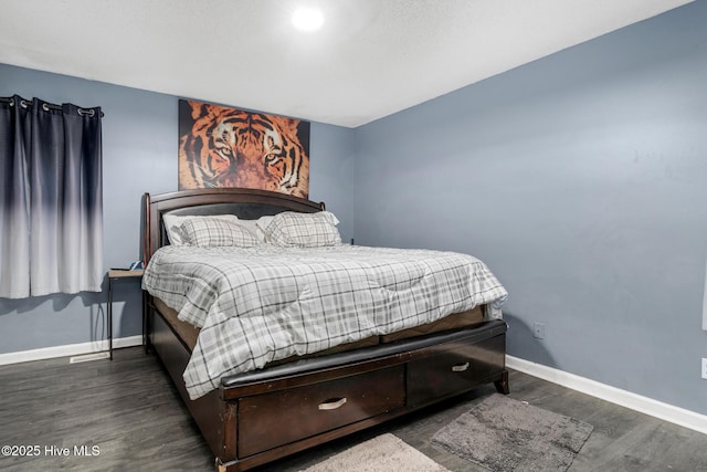 bedroom featuring dark wood-style flooring and baseboards