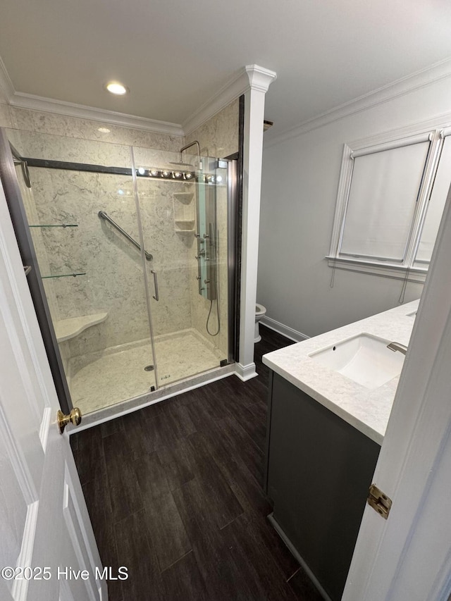 full bathroom with ornamental molding, a shower stall, toilet, and wood finished floors