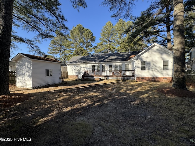 back of property featuring a deck, crawl space, an outdoor structure, and fence