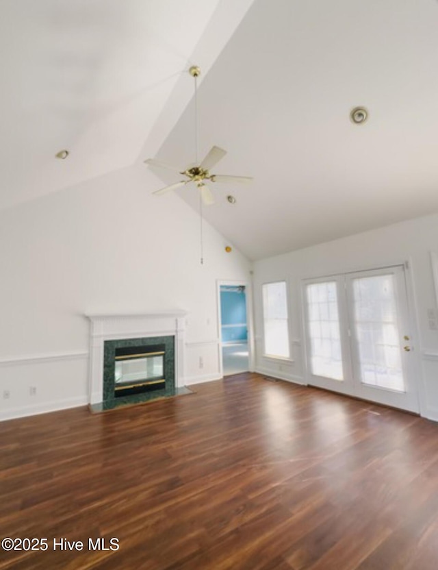 unfurnished living room with a fireplace with flush hearth, a ceiling fan, wood finished floors, high vaulted ceiling, and baseboards