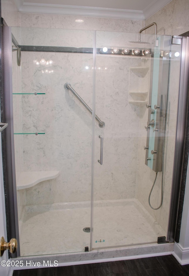 bathroom featuring crown molding and a shower stall