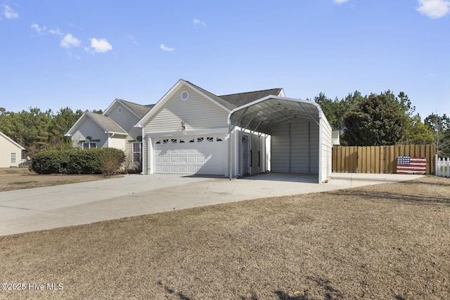 garage with concrete driveway, a carport, and fence