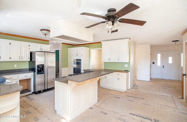 kitchen with white cabinetry, a textured ceiling, dark countertops, and stainless steel appliances