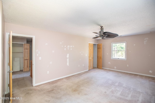 unfurnished bedroom with light carpet, a textured ceiling, and baseboards