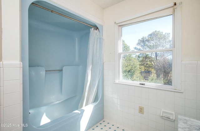 bathroom featuring wainscoting and tile walls