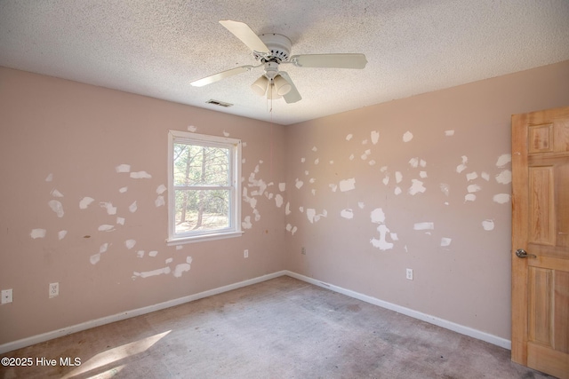 empty room featuring visible vents, baseboards, a textured ceiling, and ceiling fan