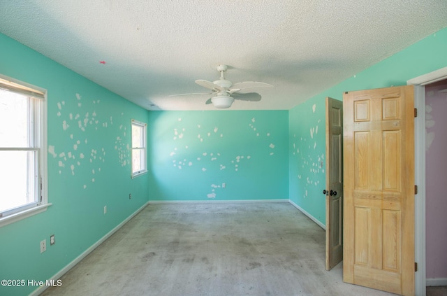 spare room featuring ceiling fan, a textured ceiling, and baseboards