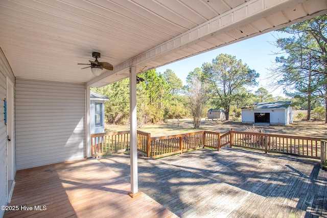 wooden terrace with an outbuilding and a ceiling fan