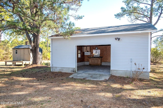 view of outbuilding with an outbuilding, a garage, and dirt driveway