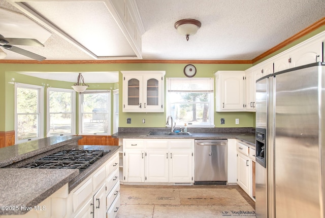 kitchen with a sink, dark countertops, white cabinetry, and stainless steel appliances