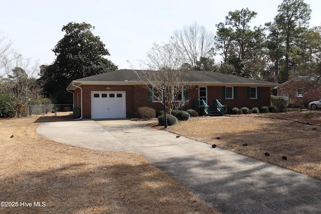 ranch-style house featuring a garage, driveway, brick siding, and fence