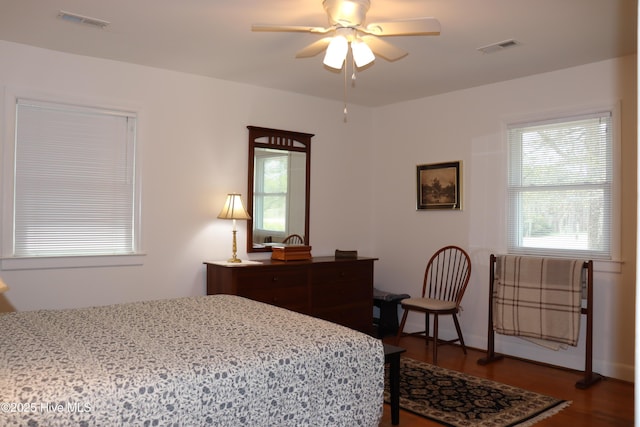 bedroom featuring ceiling fan, dark wood-style flooring, and visible vents