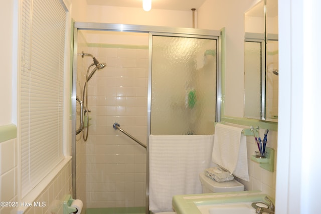 full bath featuring a stall shower and toilet