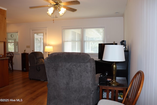 living area with a ceiling fan, dark wood-style flooring, visible vents, and plenty of natural light