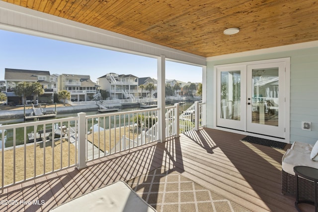 sunroom with french doors, wooden ceiling, and a residential view