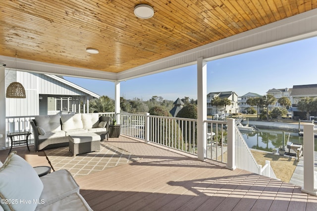 wooden deck with a water view and an outdoor living space