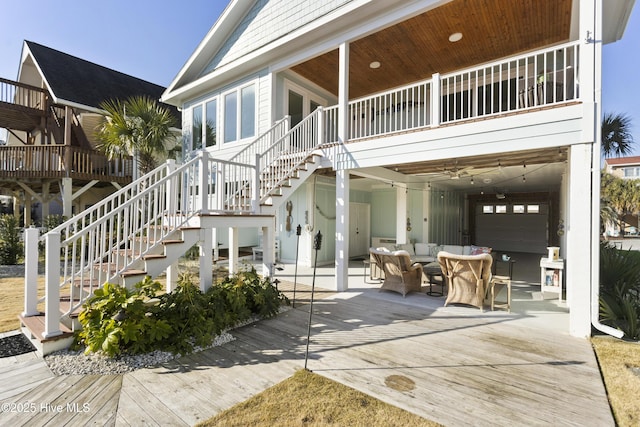 rear view of property with driveway, stairway, and an outdoor living space