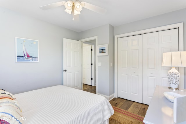 bedroom with ceiling fan, a closet, wood finished floors, and baseboards