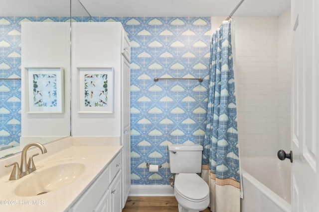 bathroom with shower / tub combo, baseboards, toilet, wood finished floors, and vanity