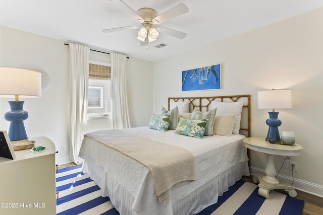 bedroom with ceiling fan, visible vents, baseboards, and wood finished floors