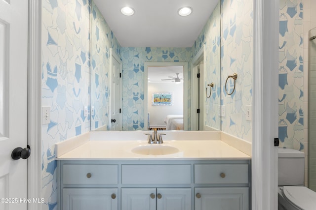 bathroom featuring connected bathroom, toilet, recessed lighting, vanity, and wallpapered walls