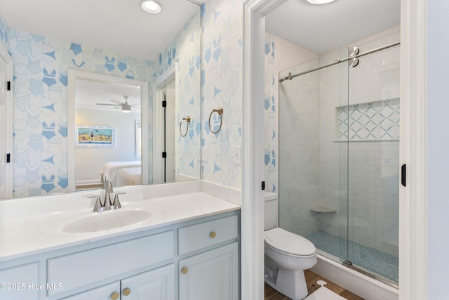 ensuite bathroom with toilet, a stall shower, connected bathroom, vanity, and wallpapered walls