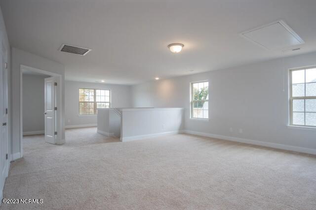 empty room with baseboards, visible vents, and a healthy amount of sunlight