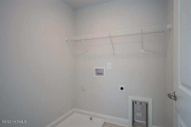 laundry room with laundry area, baseboards, hookup for a washing machine, gas dryer hookup, and hookup for an electric dryer