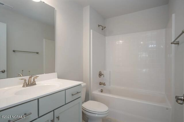 bathroom with shower / washtub combination, vanity, toilet, and visible vents