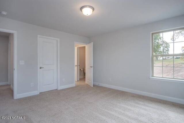 unfurnished bedroom with baseboards and light carpet