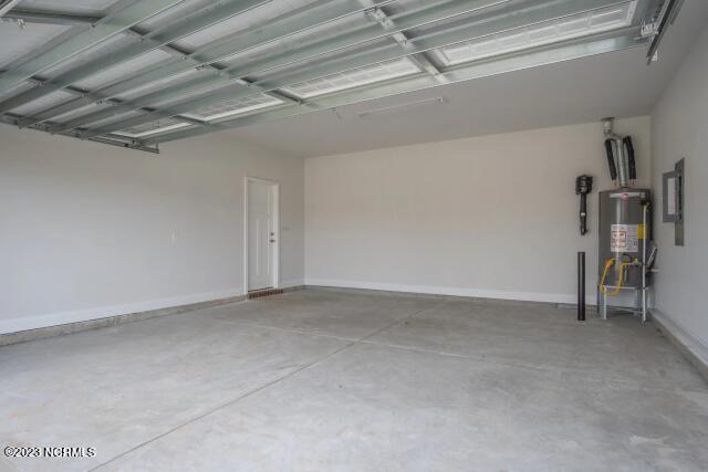 garage featuring baseboards and gas water heater