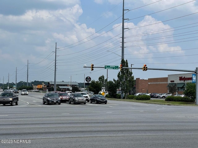 view of street with traffic lights, traffic signs, and street lights