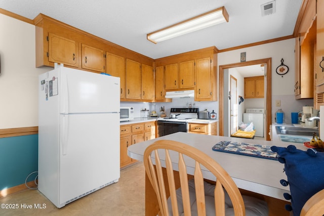 kitchen featuring under cabinet range hood, white appliances, a sink, light countertops, and washer / clothes dryer