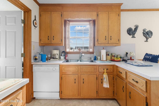 kitchen featuring crown molding, light countertops, white dishwasher, and a sink