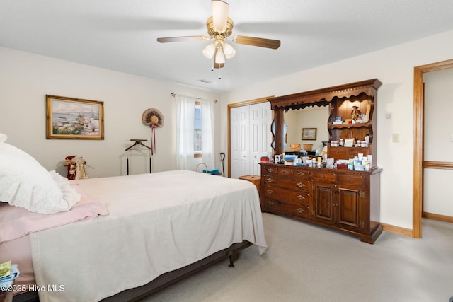 bedroom featuring light carpet, a ceiling fan, visible vents, baseboards, and a closet