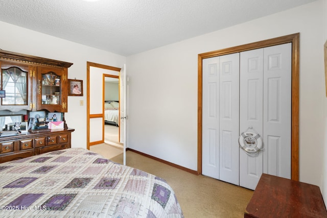 bedroom featuring a textured ceiling, a closet, baseboards, and light colored carpet