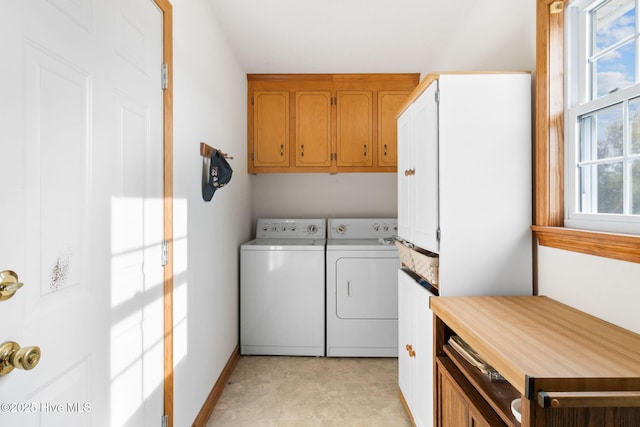 washroom with a wealth of natural light, washer and dryer, and baseboards