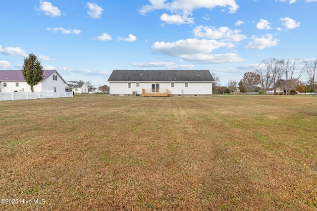 rear view of house with a yard and a wooden deck