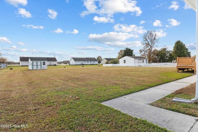 view of yard with an outdoor structure, a storage shed, and fence