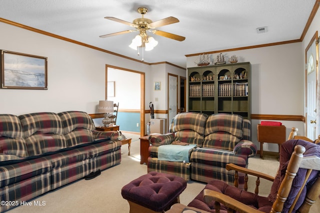 living room with light carpet, ceiling fan, ornamental molding, and visible vents